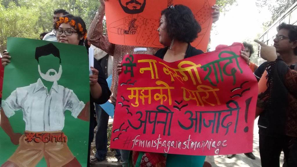 Peaceful protesters standing with posters at Mandir Marg. 