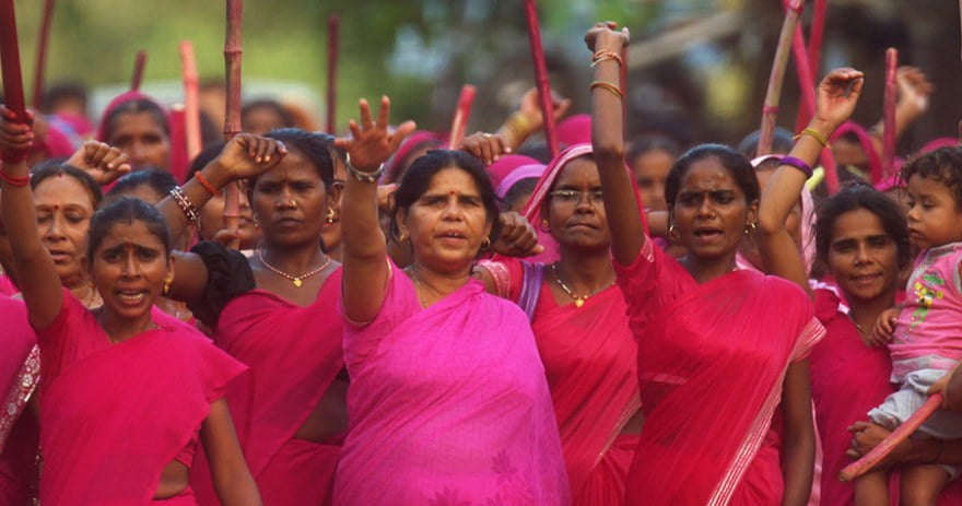 The women of Gulabi Gang wearing pink and raising slogans at a protest.