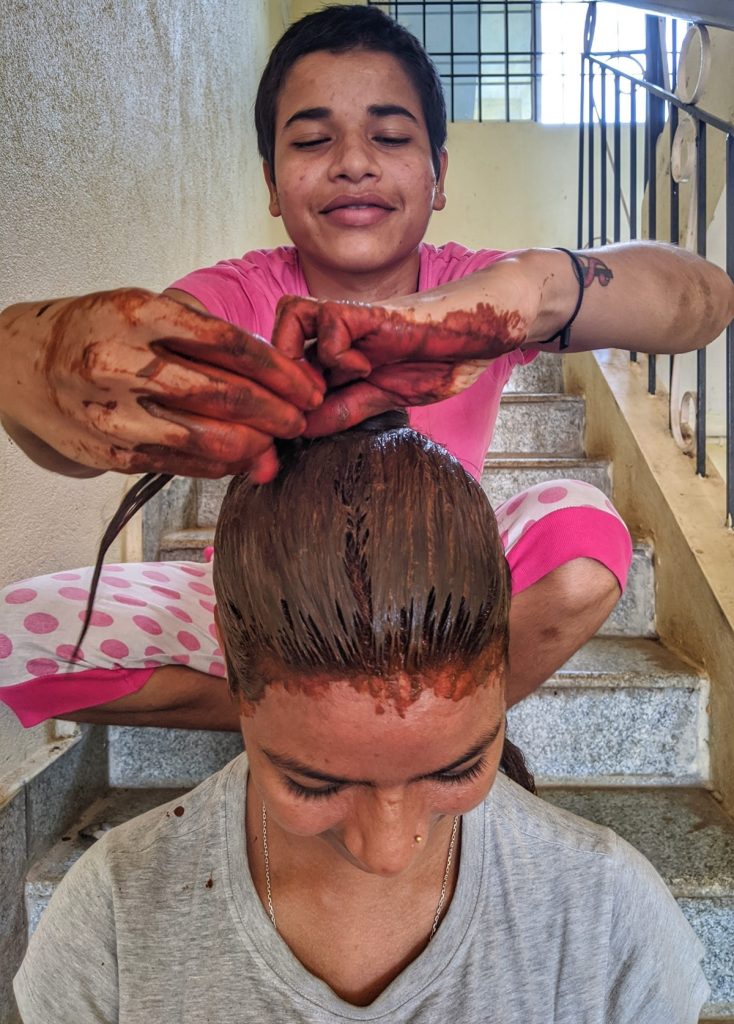 Women at Leisure: Pooja applying henna on Alka’s hair. 