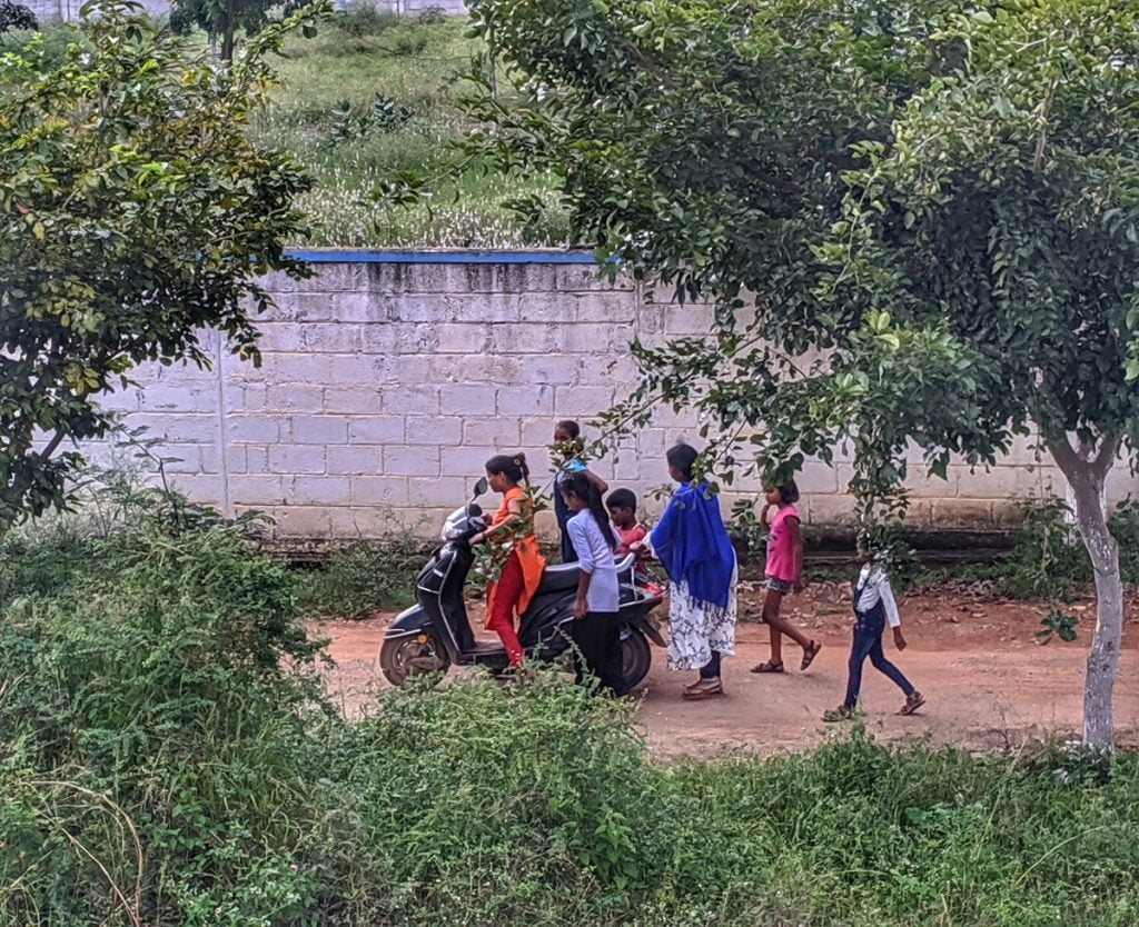 Women At Leisure: A girl’s brother finally allowed her to try the two-wheeler in the house. Girls from the neighbourhood are now helping her to learn driving, even though none of them know how to drive it. 