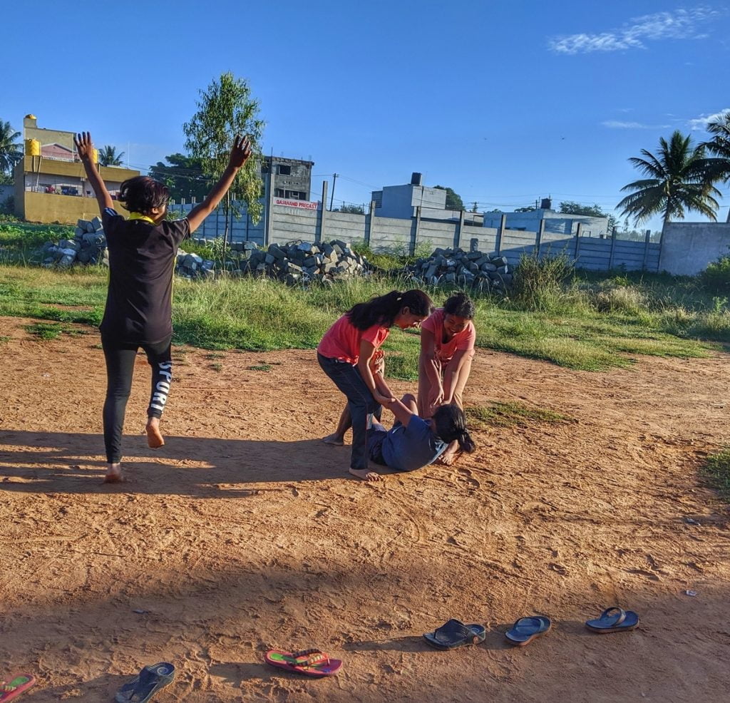 Women At Leisure: Girls playing Kabaddi early in the morning. Rinki jumps in joy as Kajal from the opposition team is taken down by her team members, Ravina and Neelam. 