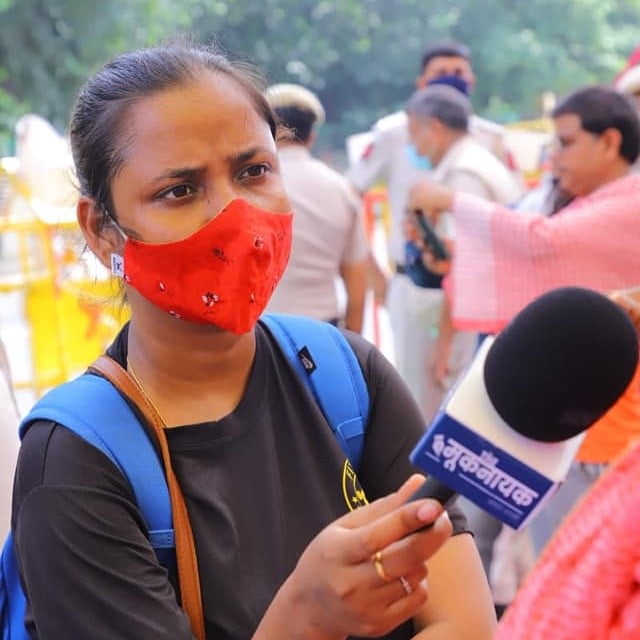 Meena Kotwal interviewing someone with a mic in hand