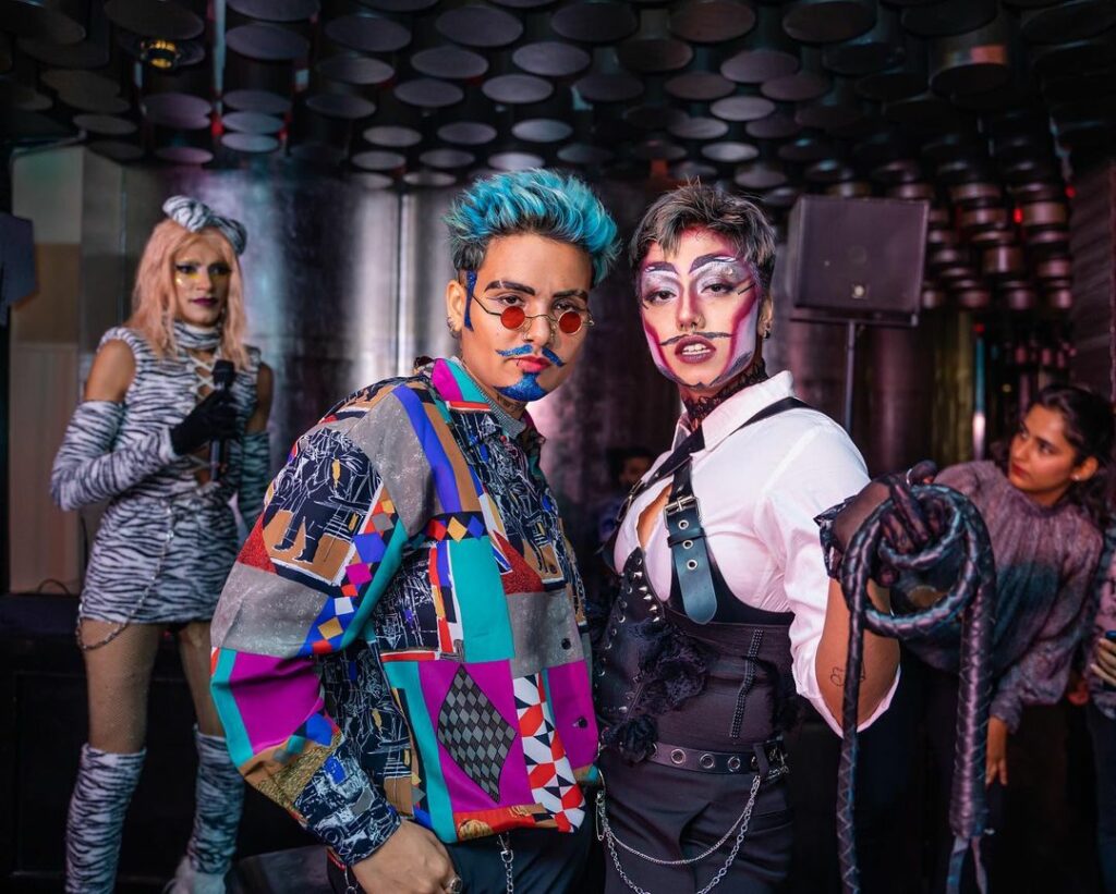Drag King Mx. Siaan standing in costume with another drag artist 