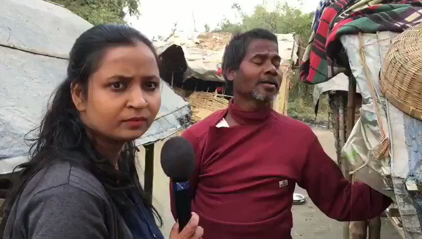 Meena Kotwal with a mic in hand standing next to a distressed man 