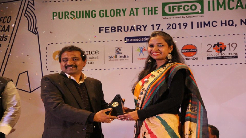 Meena Kotwal wearing coloured saree receiving an award 