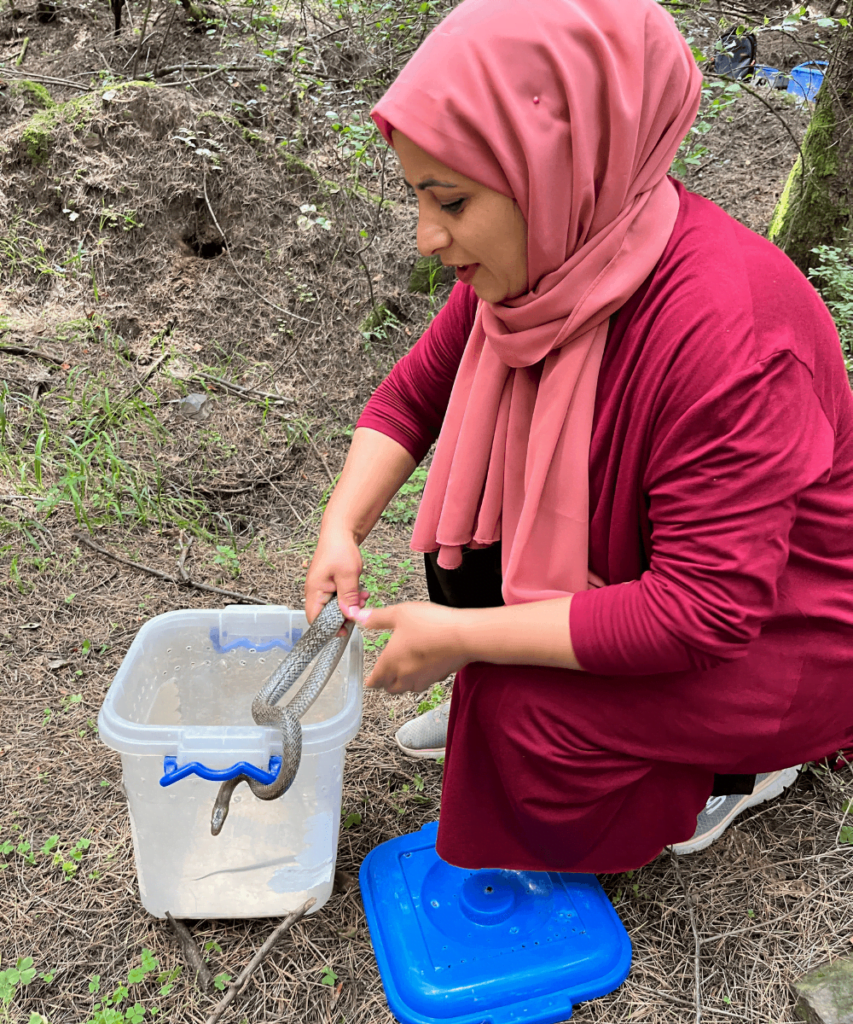 Aliya Mir, wildlife rescuer, with a snake in her hands