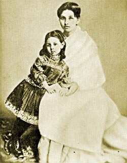 Pandita Ramabai sitting on a chair with a childstanding next to her 