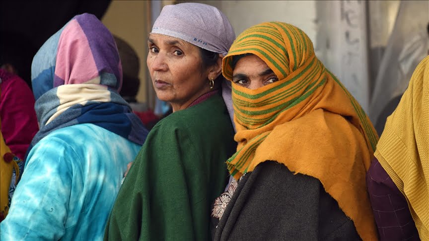 Three Kashmiri women in a queue  