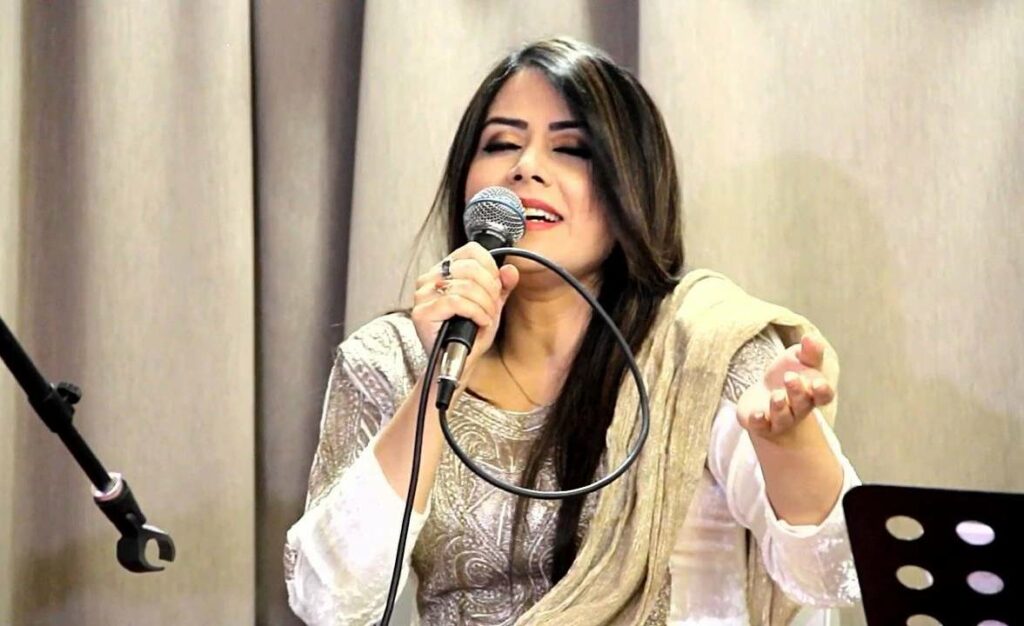 Kashmiri woman singer Mehmeet singing with a mic in her hand 