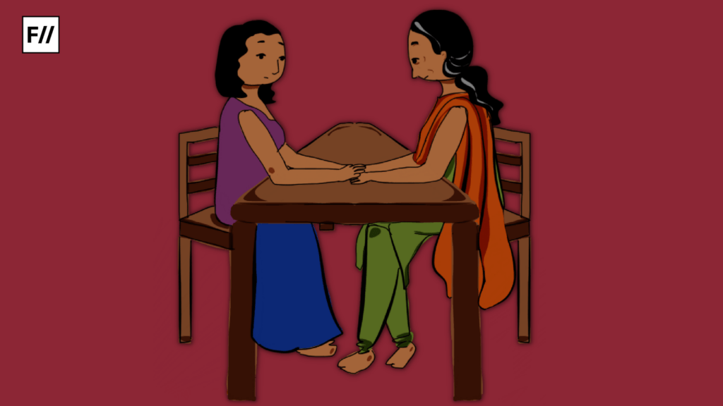 Mother and daughter sitting together on a table and chair holding hands