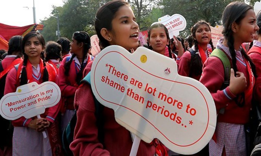 Woman carrying placard: "There are lot more to shame than periods..."