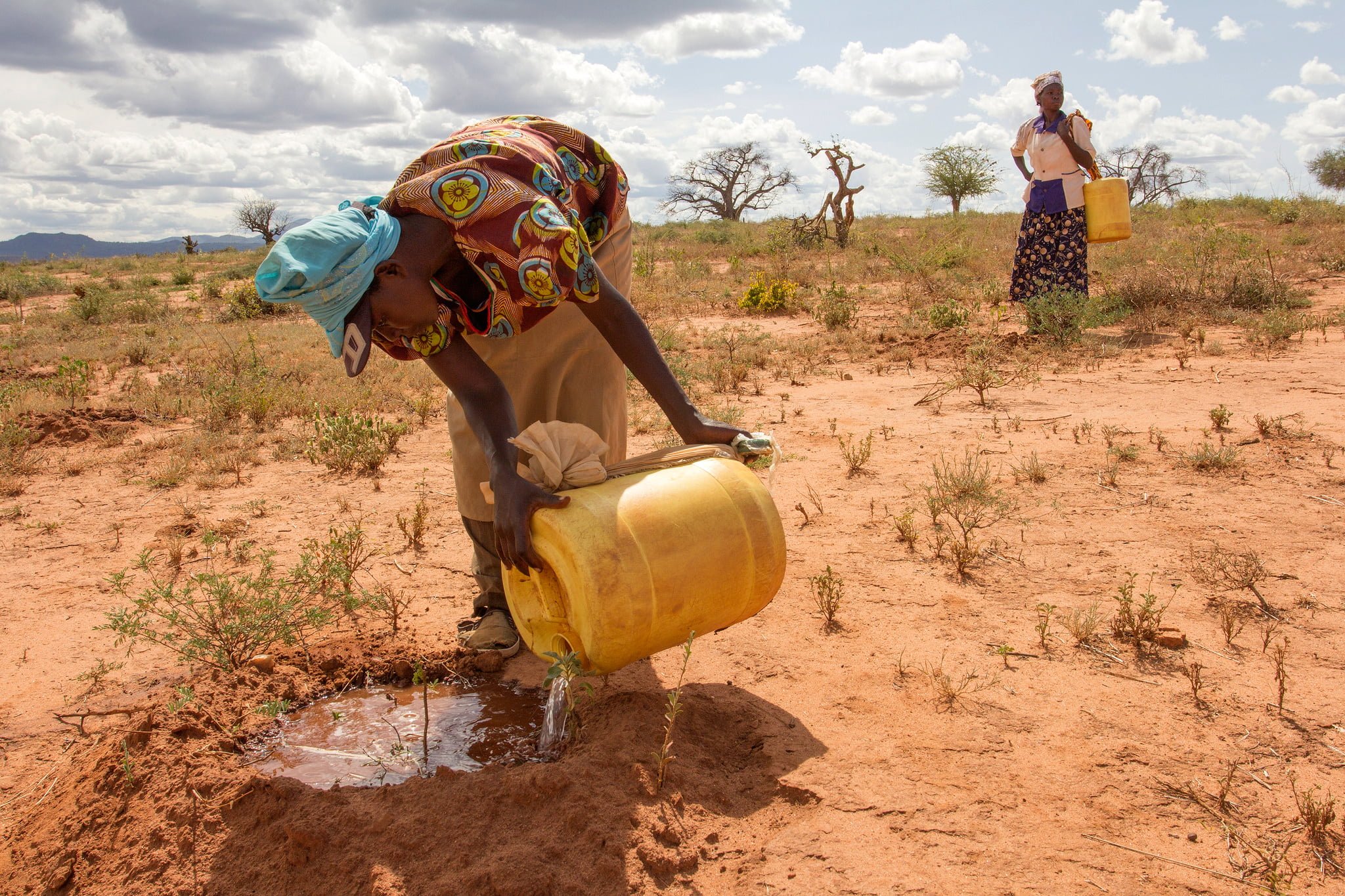 Woman watering arid land