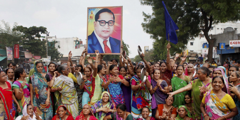 Dalit women protesting with a poster of BR Ambedkar 