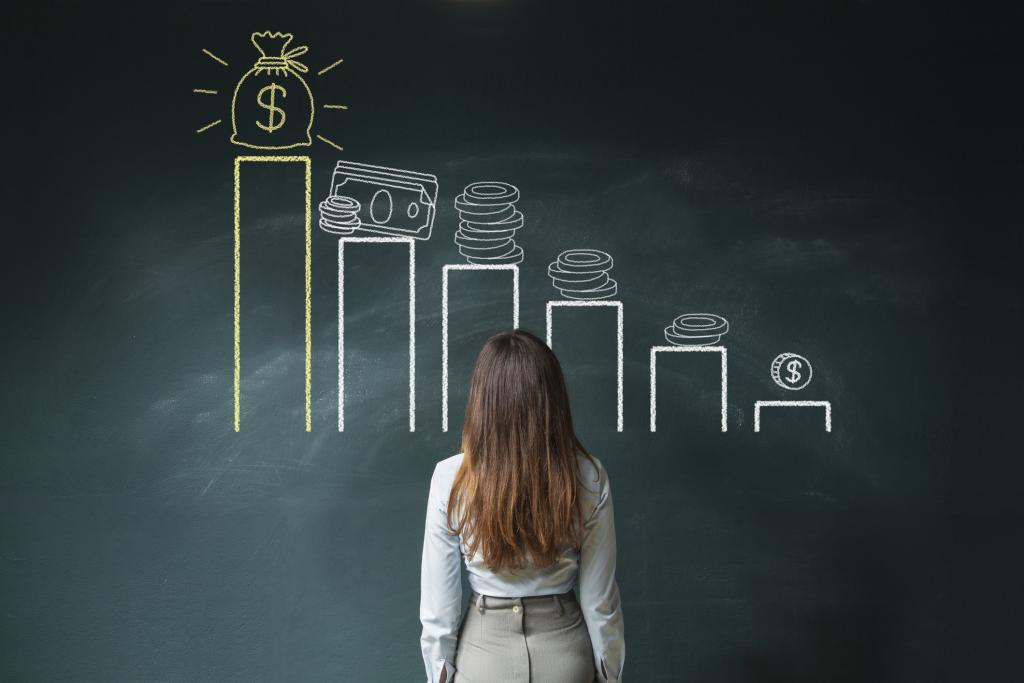A woman looking at a bar diagram on a chalkboard
