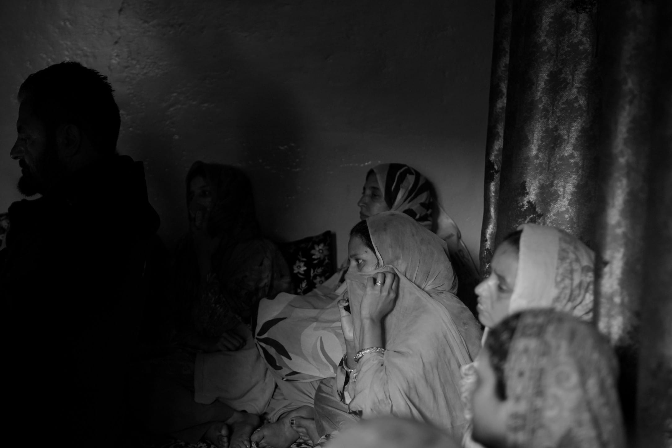 Relatives mourn in silence and sorrow after Nargis was killed in the India-Pakistan cross-border shelling. The pain of sudden loss hangs heavy in the air.